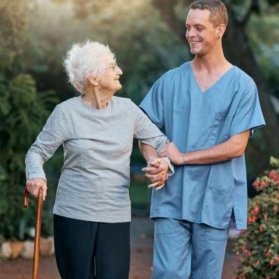 Nurse, senior woman and walking in park for healthcare and wellness. Physiotherapy, rehabilitation .