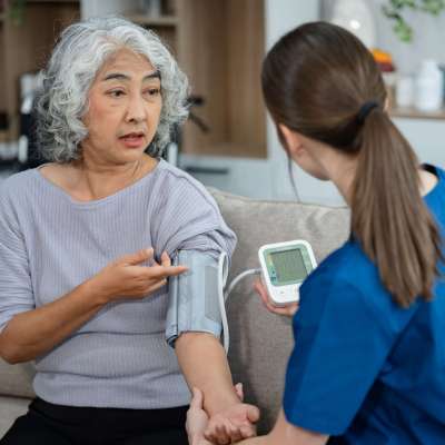 young caregiver assists her elderly woman patient at a nursing home. senior woman is assisted by a nurse at home.